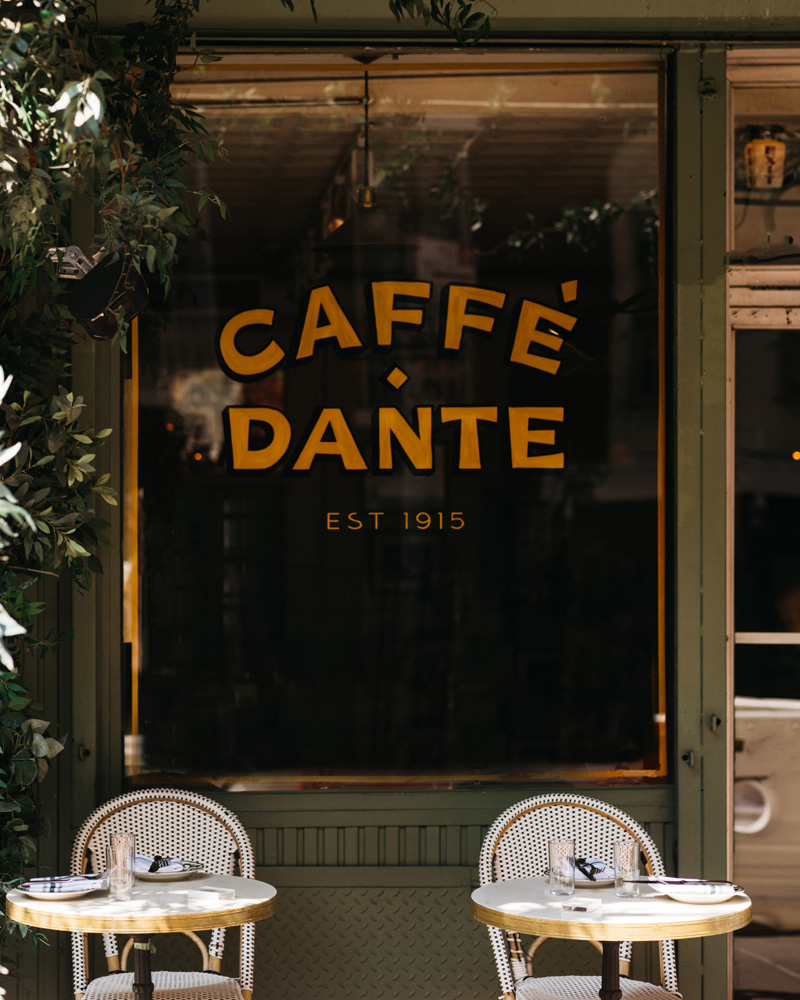 Close up of the exterior window to Caffe Dante in New York City known for its classic cocktails and European cafe decor.